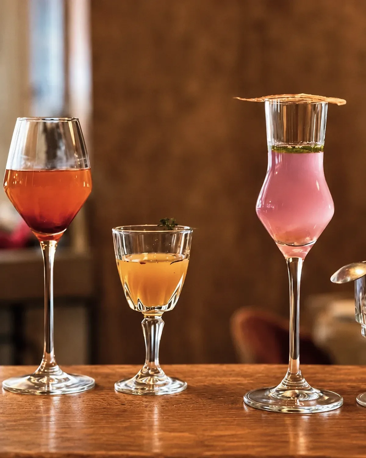 Quatre créations sans alcool aux couleurs et textures variées, alignées sur un comptoir en bois.